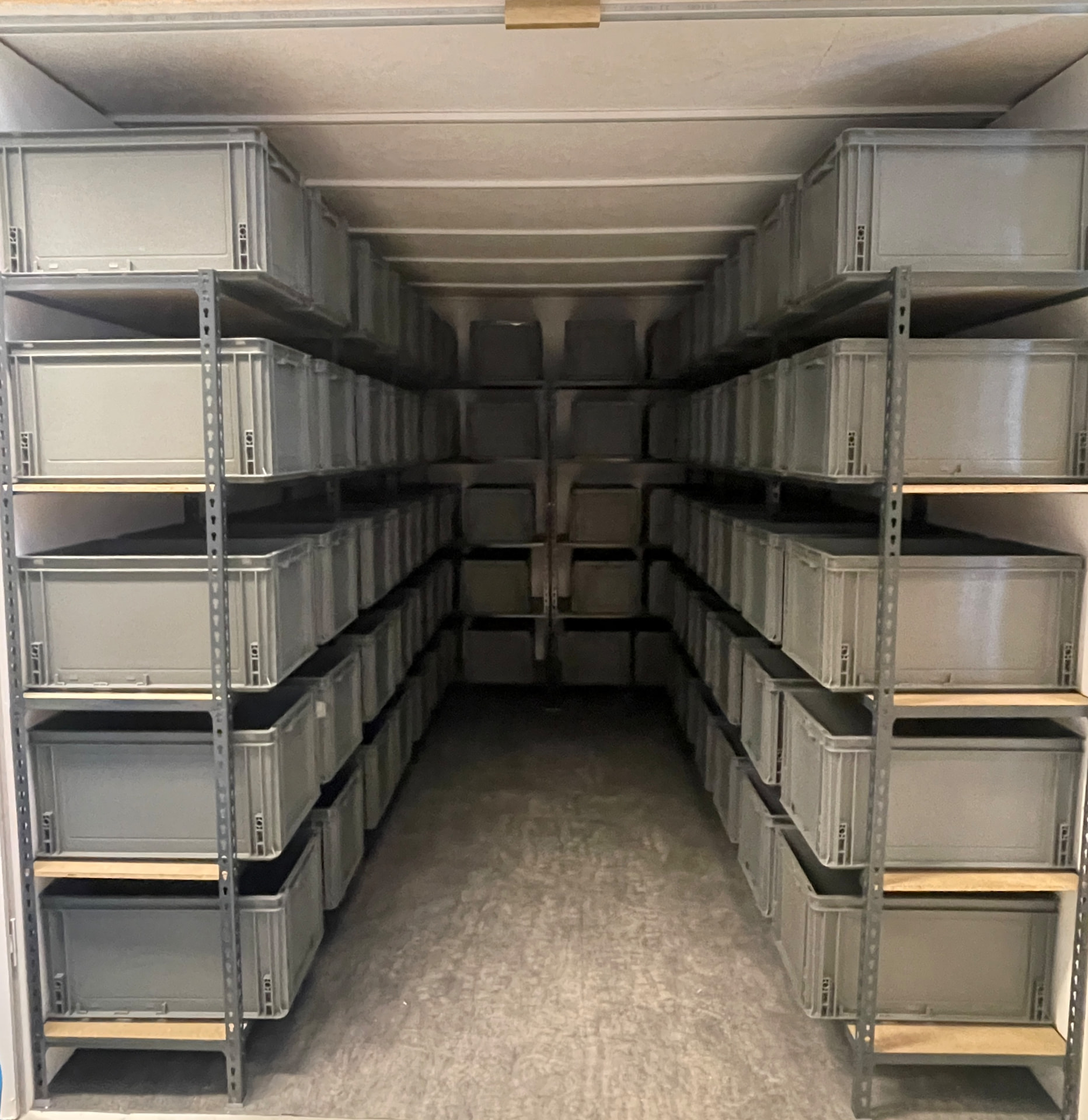 Shelves of grey plastic storage crates inside a Tidal Marine storage room