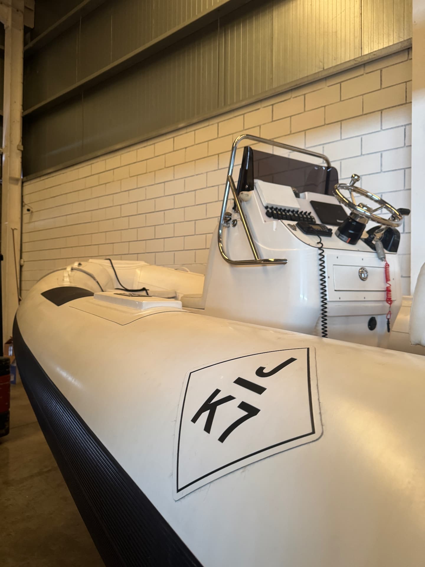 White RIB tender with centre console stored indoors at the Tidal Marine facility